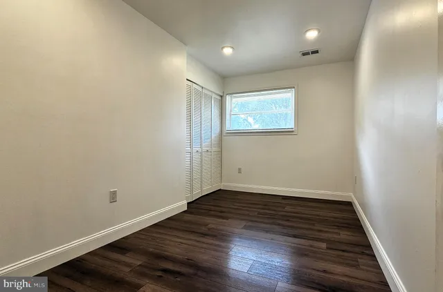 a view of an empty room with wooden floor