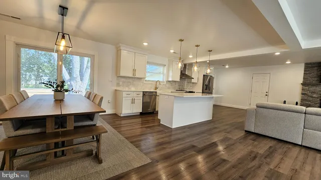 a large kitchen with cabinets a sink a counter space and stainless steel appliances