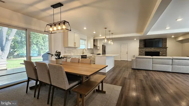a view of a dining room and livingroom with furniture wooden floor a chandelier