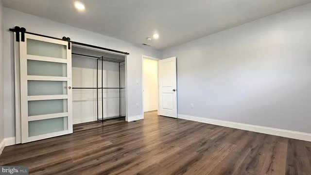 a view of empty room with wooden floor and window