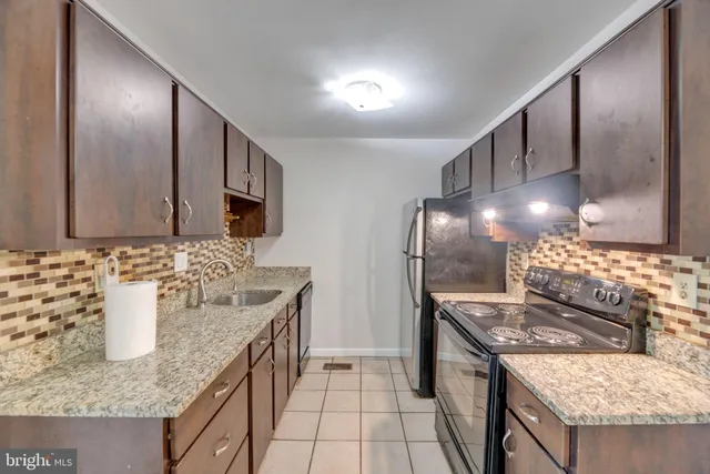 a kitchen with stainless steel appliances granite countertop a sink and a stove