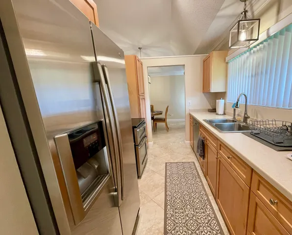 a kitchen with sink a refrigerator and wooden floor