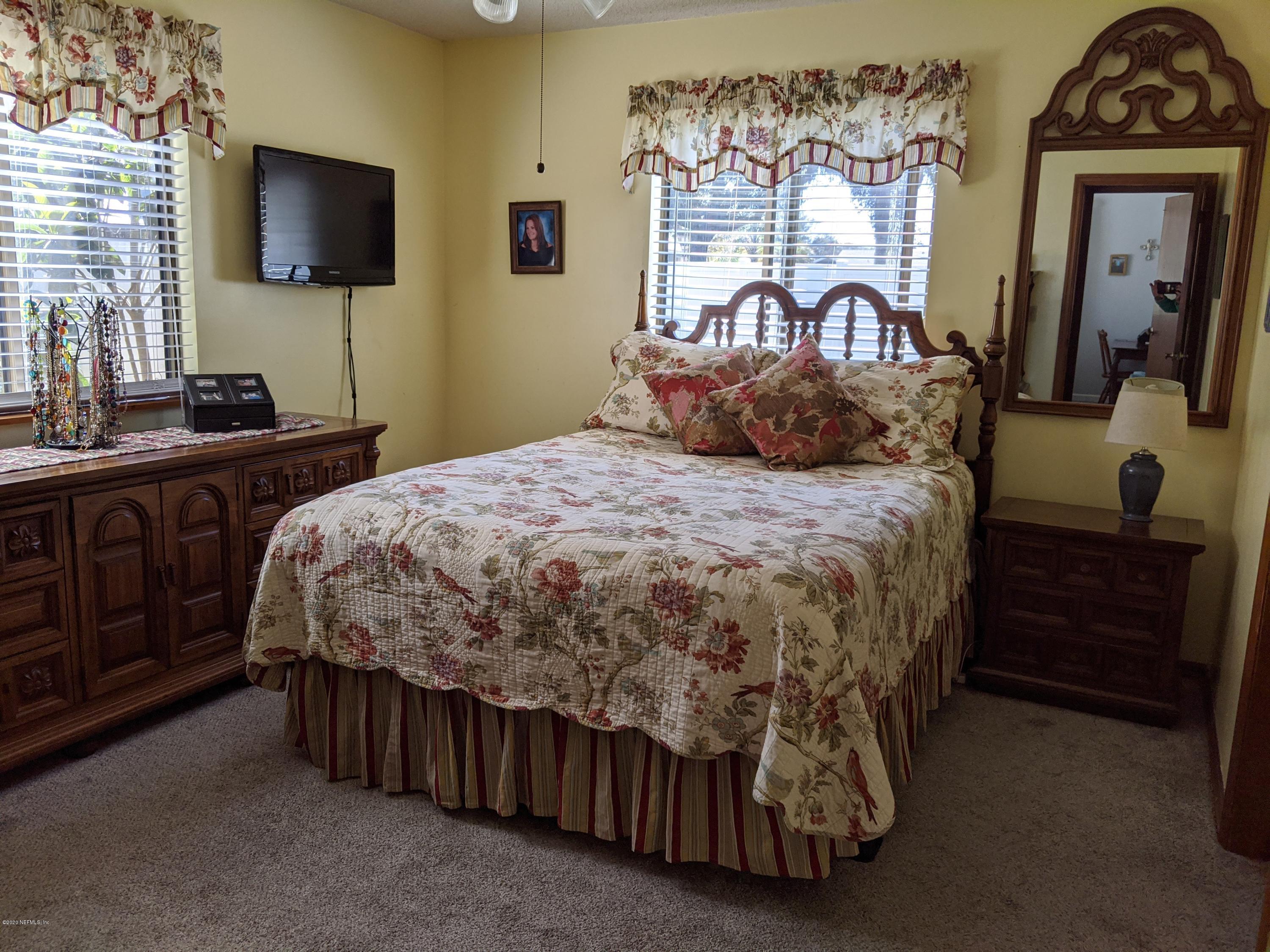 106 Jasmine Road St. Augustine, FL 32086 - Photo 6 of 11 a bedroom with a bed and a flat tv screen on dresser