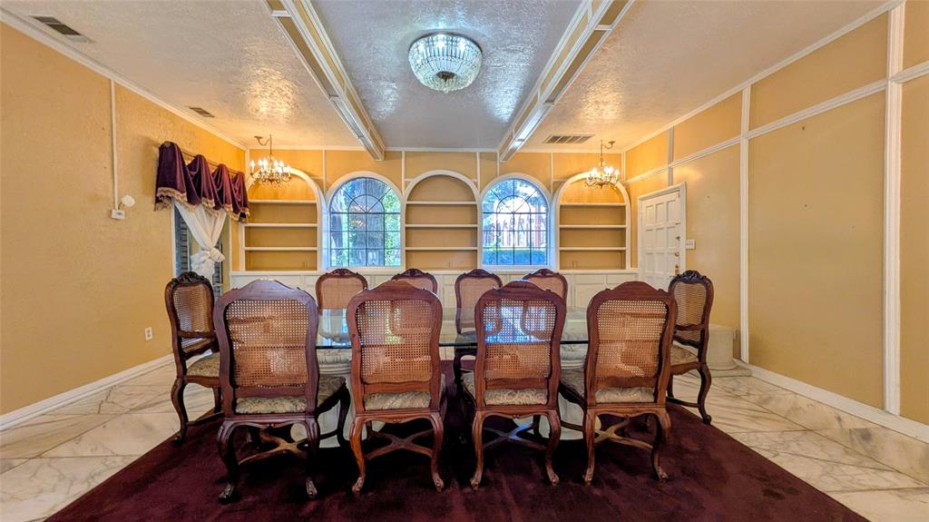 1431 South Houston School Road Lancaster, TX 75146 - Photo 20 of 39 Spacious room featuring arched built-in shelving, two arched windows, and a classic chandelier