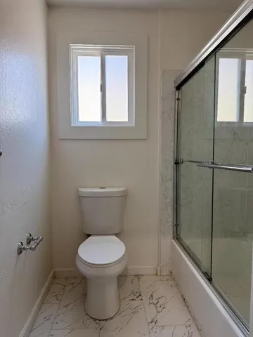 a bathroom with a toilet and a shower