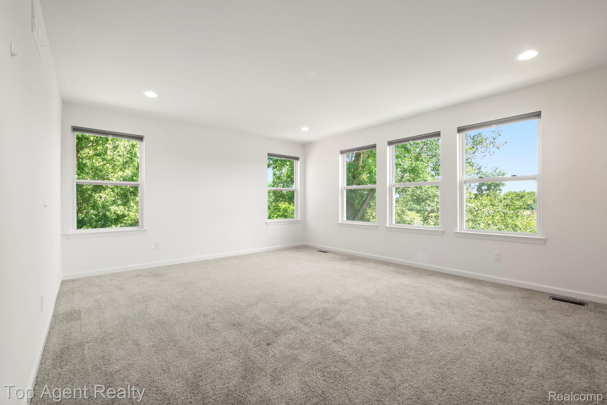 63770 Dequindre Road Washington, MI 48095 - Photo 27 of 61 Spacious room featuring five large windows, light gray carpeting, crisp white walls, recessed lighting, and white trim