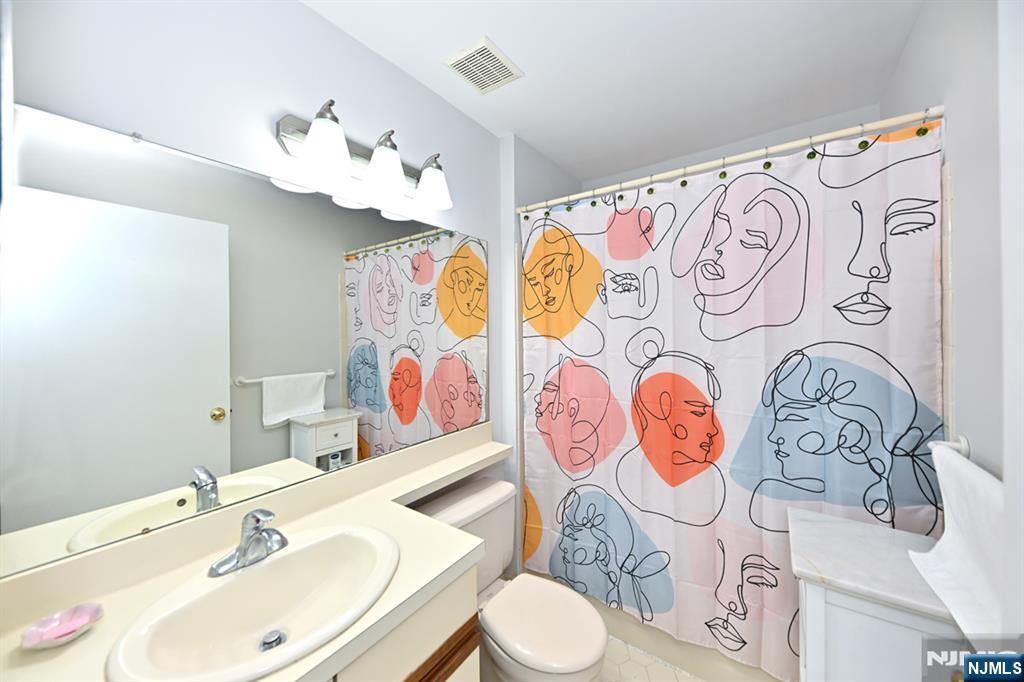 250 Larch Lane Mahwah, NJ 07430 - Photo 20 of 24 a bathroom with a sink and mirror with toilet