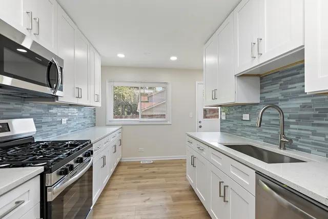 a kitchen with stainless steel appliances granite countertop a sink stove oven and refrigerator
