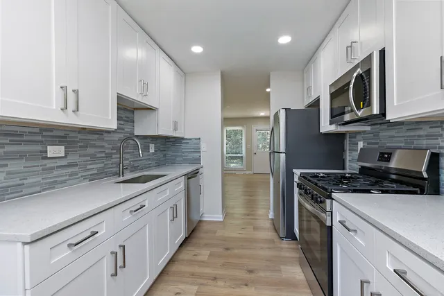 a kitchen with stainless steel appliances granite countertop a stove a sink and a microwave
