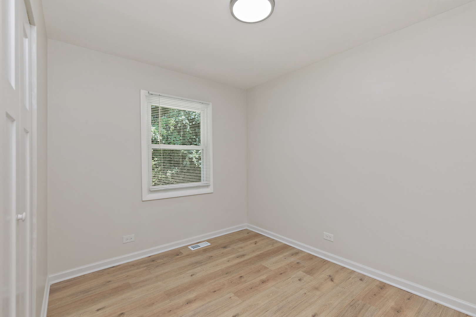 1101 Colony Court Streamwood, IL 60107 - Photo 10 of 16 a view of an empty room with wooden floor and a window