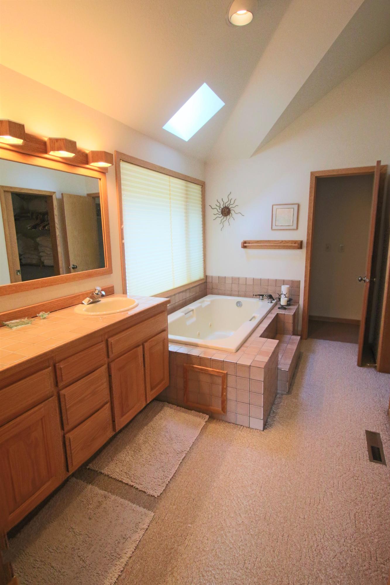 17693 Bittern Lane Sunriver, OR 97707 - Photo 11 of 15 The large widow in the Master Bath lets the day spill in. Besides the large tub, there is a shower.