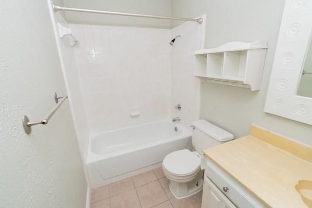 106 Mapleleaf Lane Coppell, TX 75019 - Photo 31 of 36 Bathroom featuring a tub and shower combination with white tile surround, a single vanity with light-toned countertop, and a white cabinet with shelving