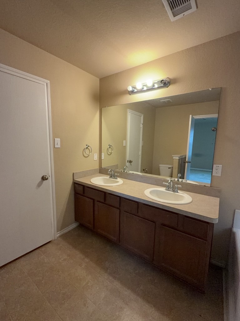 811 Lovebug Lane Conroe, TX 77301 - Photo 7 of 9 a bathroom with double vanity sink and a mirror
