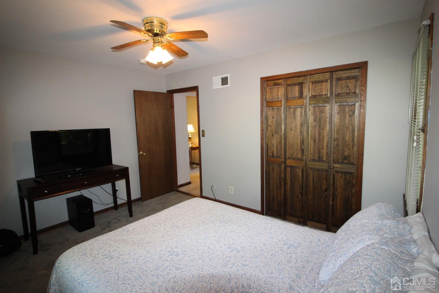 26 Homestead Road Edison, NJ 08820 - Photo 14 of 34 a bedroom with a bed and a flat tv screen on dresser