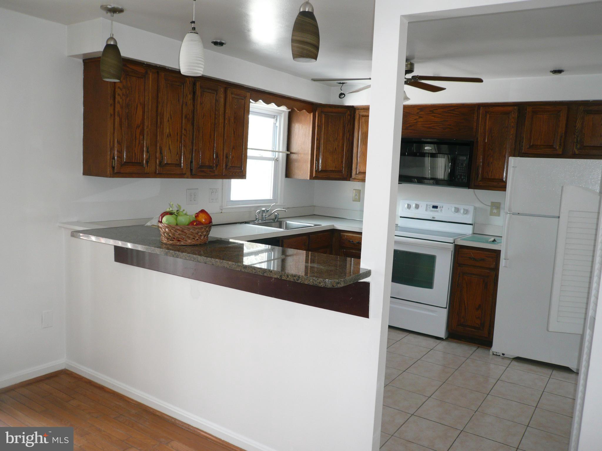 8512 Contee Road Laurel, MD 20708 - Photo 8 of 20 a kitchen with stainless steel appliances a stove a microwave a sink and cabinets