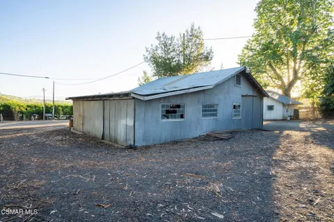 a view of a house with a yard and large tree