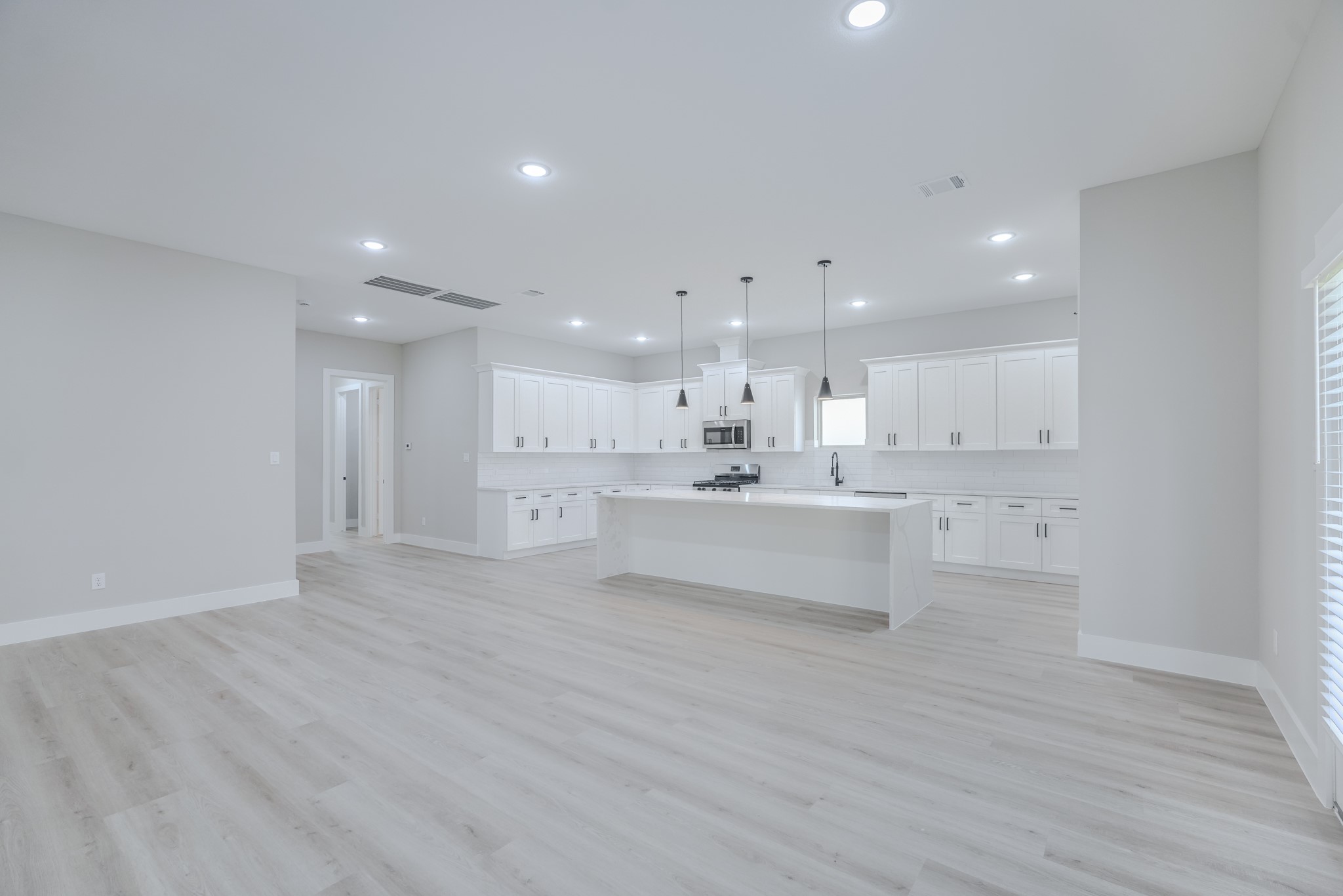 2618 Piemonte Avenue Cir Spring Spring, TX 77388 - Photo 13 of 50 a large white kitchen with kitchen island a sink white cabinets and a refrigerator