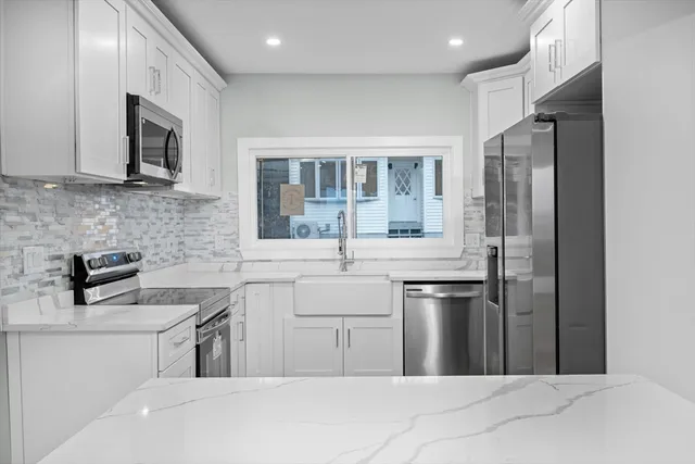 a kitchen with stainless steel appliances a sink stove and refrigerator