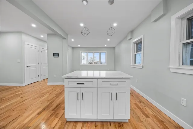 a kitchen with a stove cabinets and a wooden floor