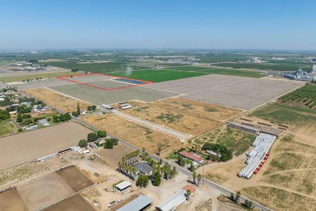 an aerial view of ocean and residential houses with outdoor space