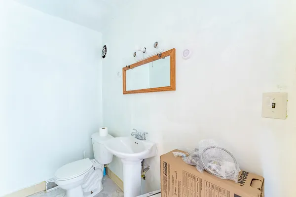 a bathroom with a toilet a sink and a mirror