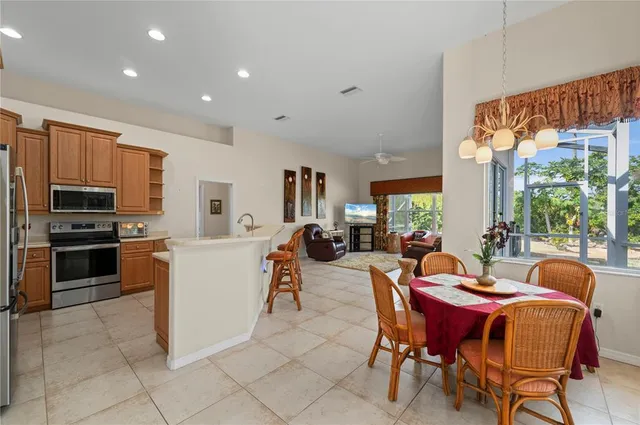 a kitchen with stainless steel appliances kitchen island granite countertop a refrigerator and a sink