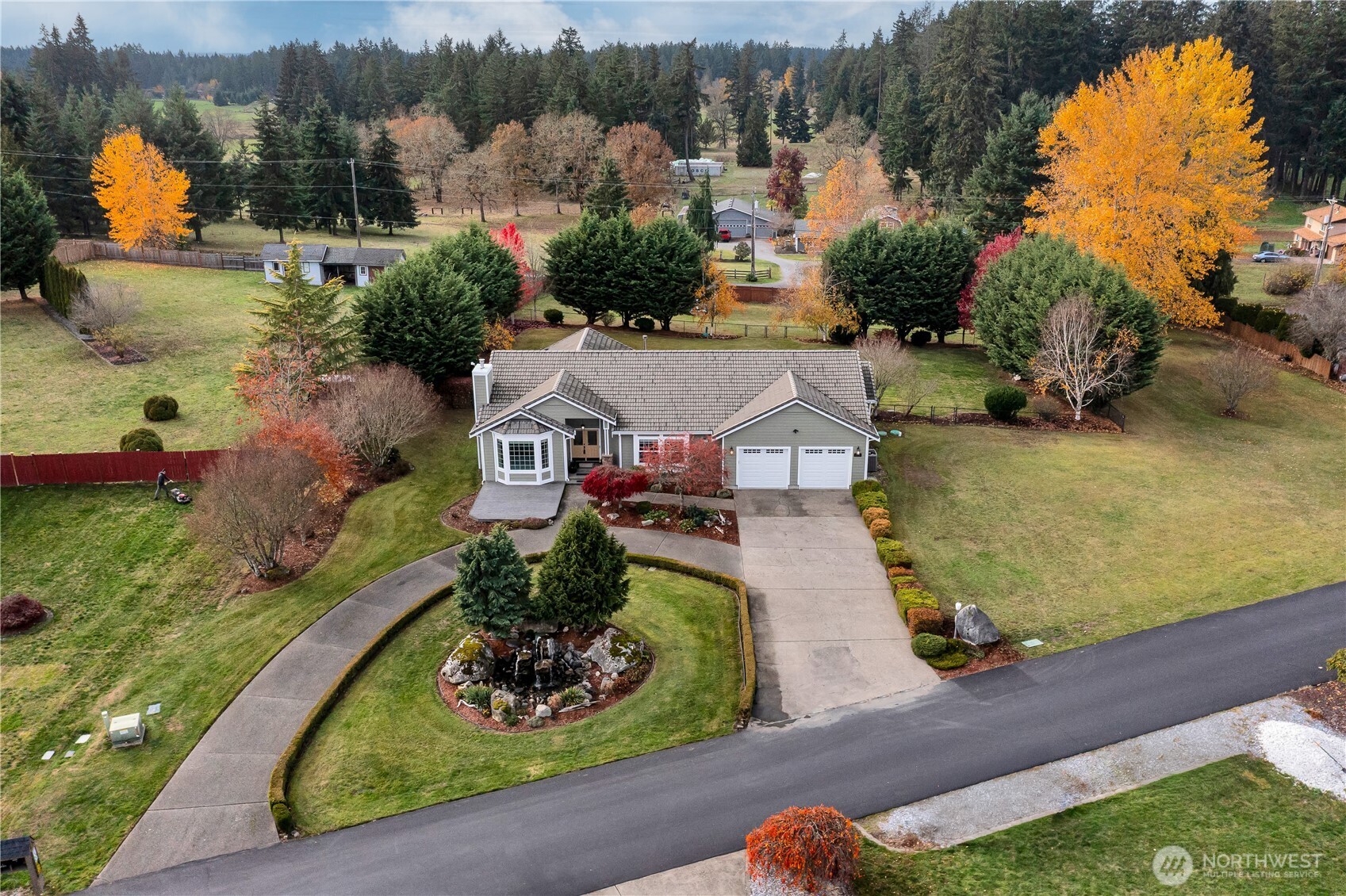 an aerial view of a house with a garden and lake view