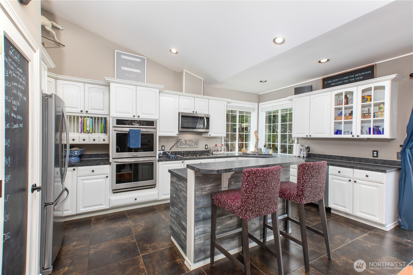 29216 39th Avenue South Roy, WA 98580 - Photo 21 of 38 a kitchen with stainless steel appliances granite countertop a stove top oven a sink dishwasher a refrigerator and white cabinets with wooden floor