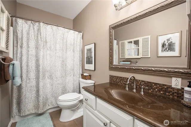a bathroom with a granite countertop sink a toilet and a mirror