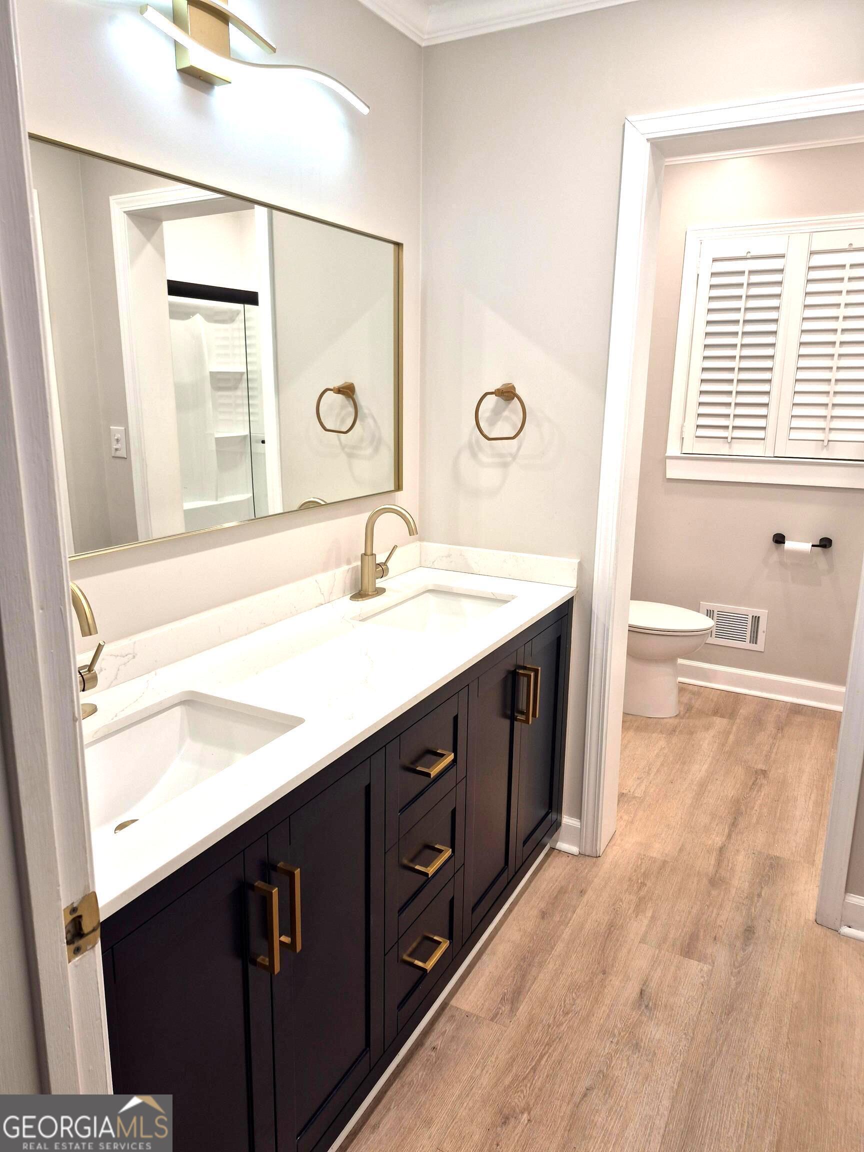 930 Hill Place Macon, GA 31210 - Photo 20 of 34 a bathroom with a double vanity sink a mirror and a bathtub