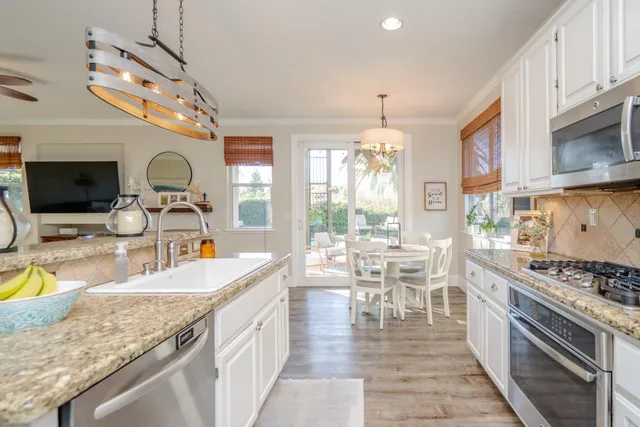 a kitchen with stainless steel appliances granite countertop a stove and a wooden floors