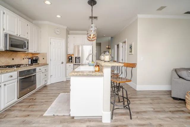 a kitchen with a table chairs microwave and cabinets