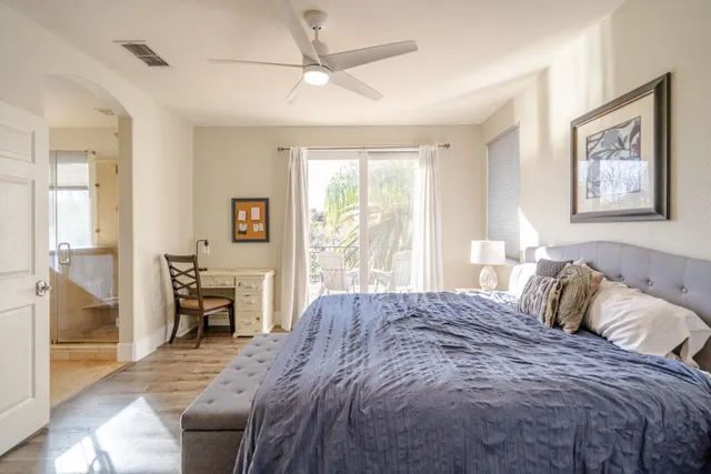 a bedroom with a large bed next to a window and a chandelier