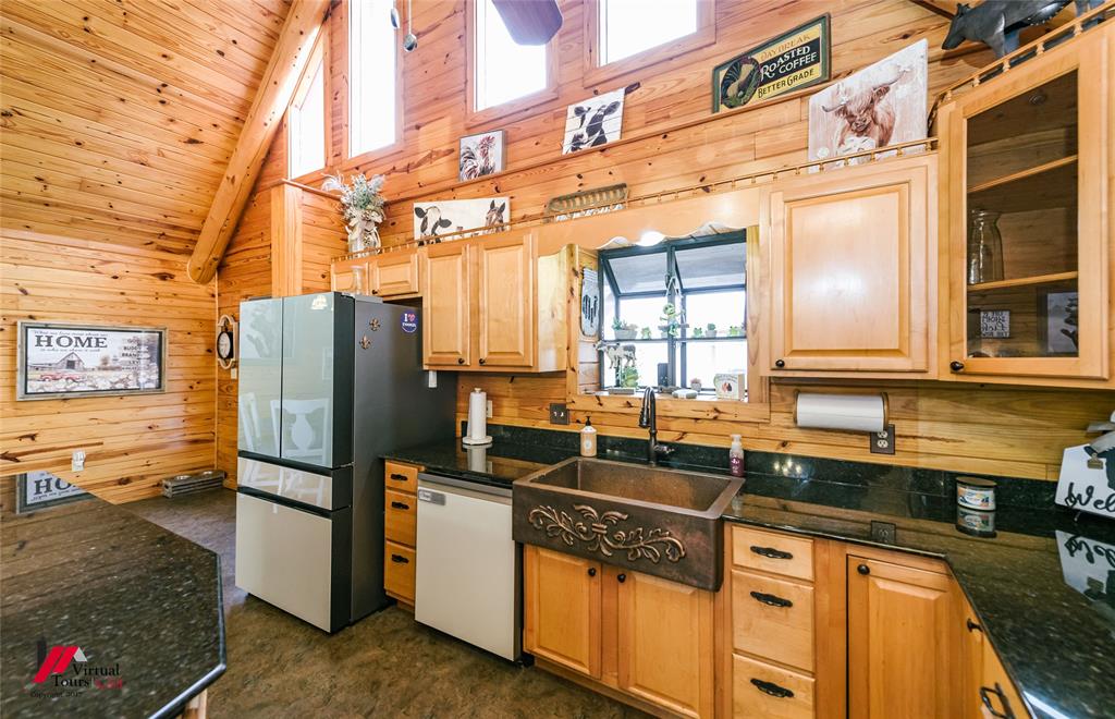 550 Middleton Road Stonewall, LA 71078 - Photo 13 of 40 a kitchen with stainless steel appliances granite countertop a refrigerator a sink and wooden cabinets