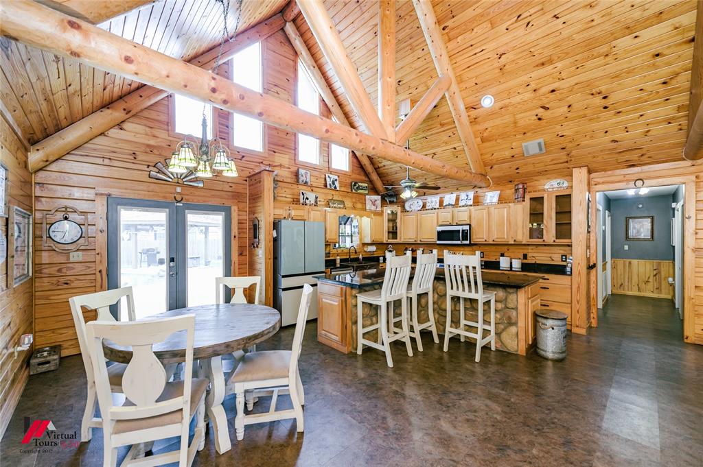 550 Middleton Road Stonewall, LA 71078 - Photo 15 of 40 a dining room with wooden floor a chandelier a wooden table and chairs