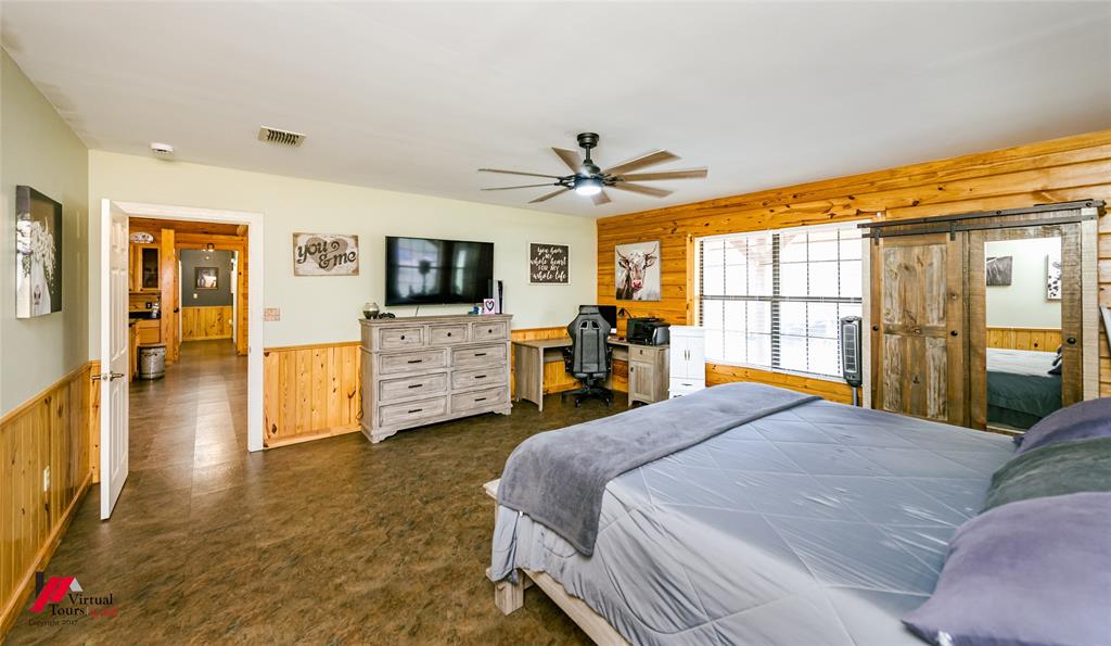 550 Middleton Road Stonewall, LA 71078 - Photo 19 of 40 a spacious bedroom with a large bed a flat tv screen and a dresser