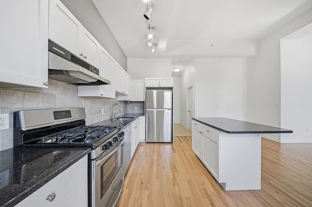 a kitchen with stainless steel appliances granite countertop a stove and a refrigerator