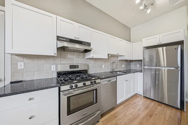 a kitchen with stainless steel appliances white cabinets and a stove