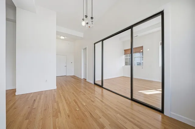a view of empty room with wooden floor