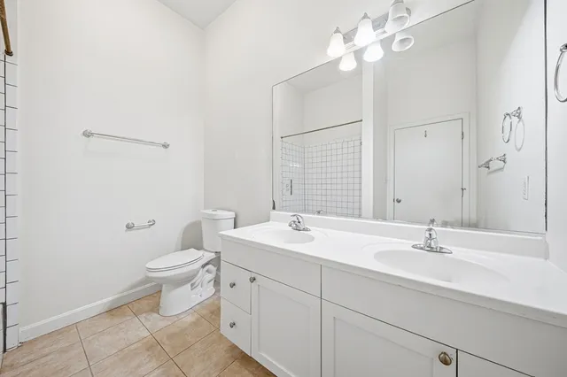 a bathroom with a sink a toilet and a mirror