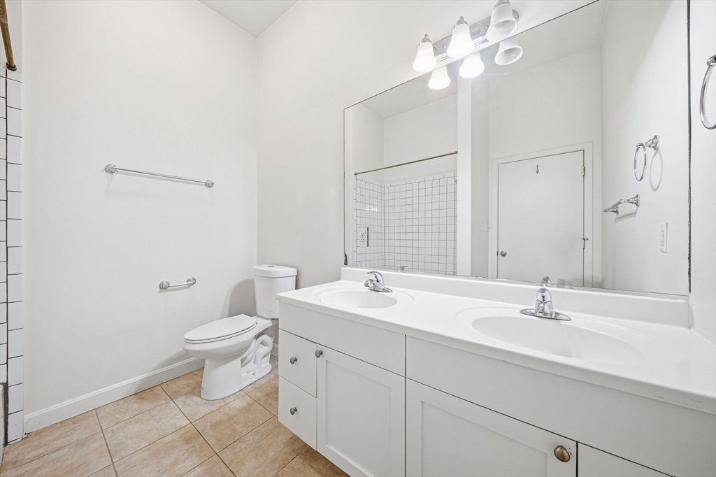 156 Chelsea Street, Unit 103 Boston, MA 02128 - Photo 16 of 27 a bathroom with a sink a toilet and a mirror