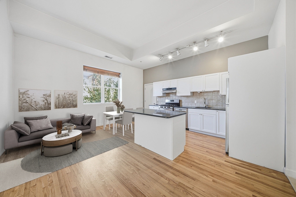 156 Chelsea Street, Unit 103 Boston, MA 02128 - Photo 3 of 27 a living room with furniture and view of kitchen
