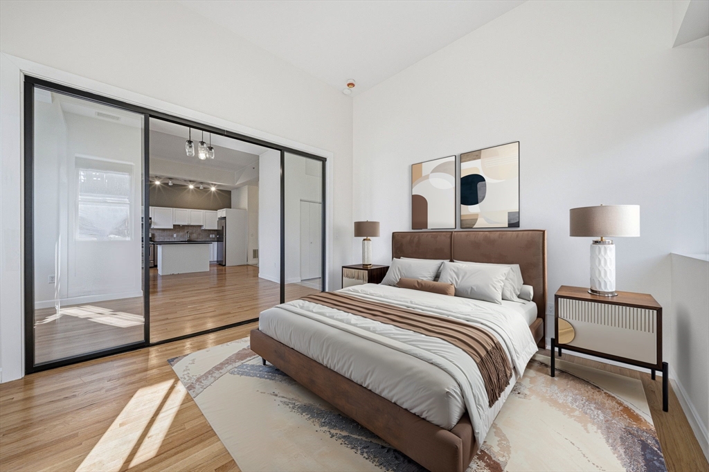 156 Chelsea Street, Unit 103 Boston, MA 02128 - Photo 6 of 27 a spacious bedroom with a bed and a walk in closet