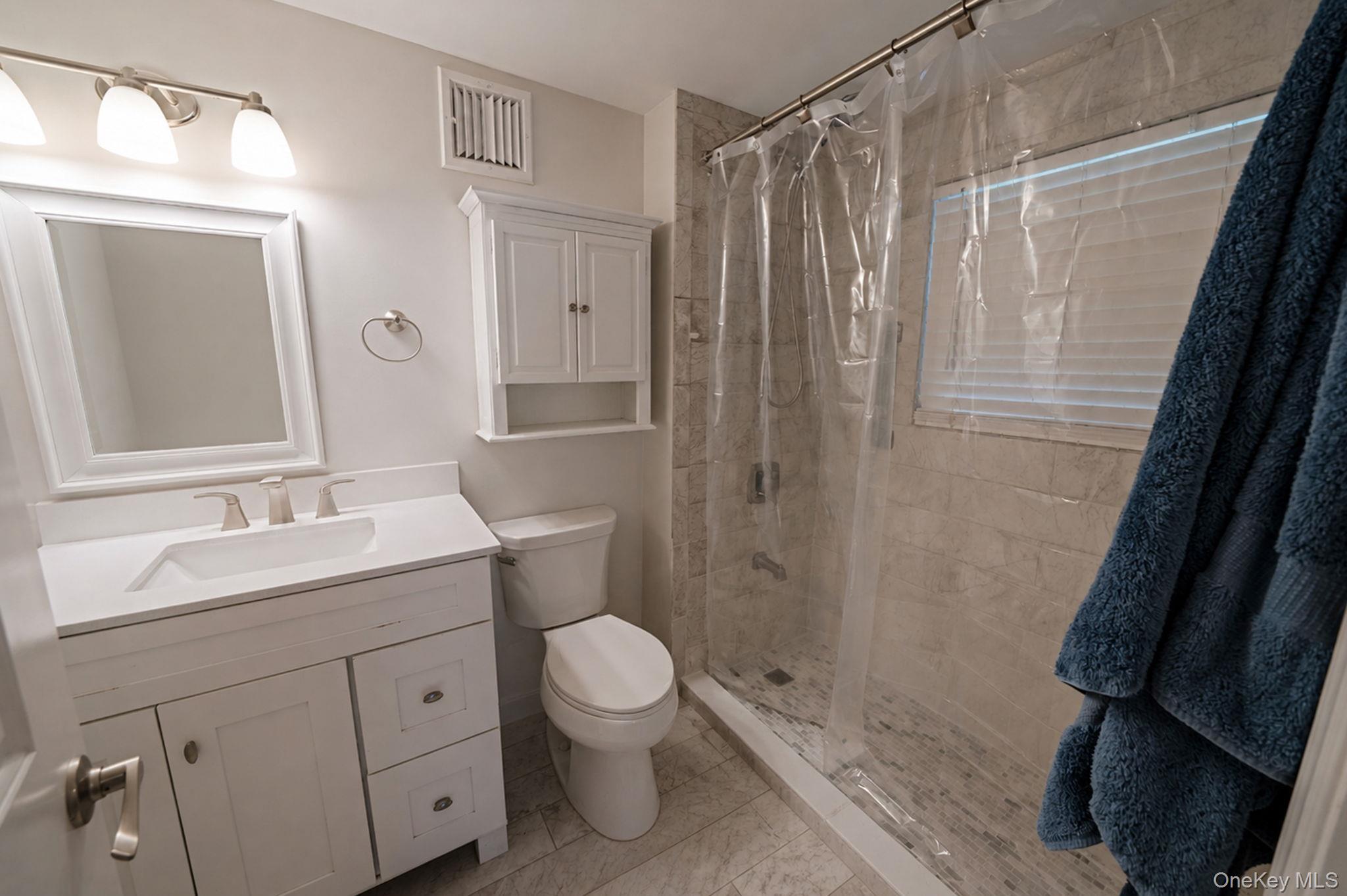 110 Stephen Road Bayport, NY 11705 - Photo 35 of 39 a bathroom with a sink a toilet a mirror and shower