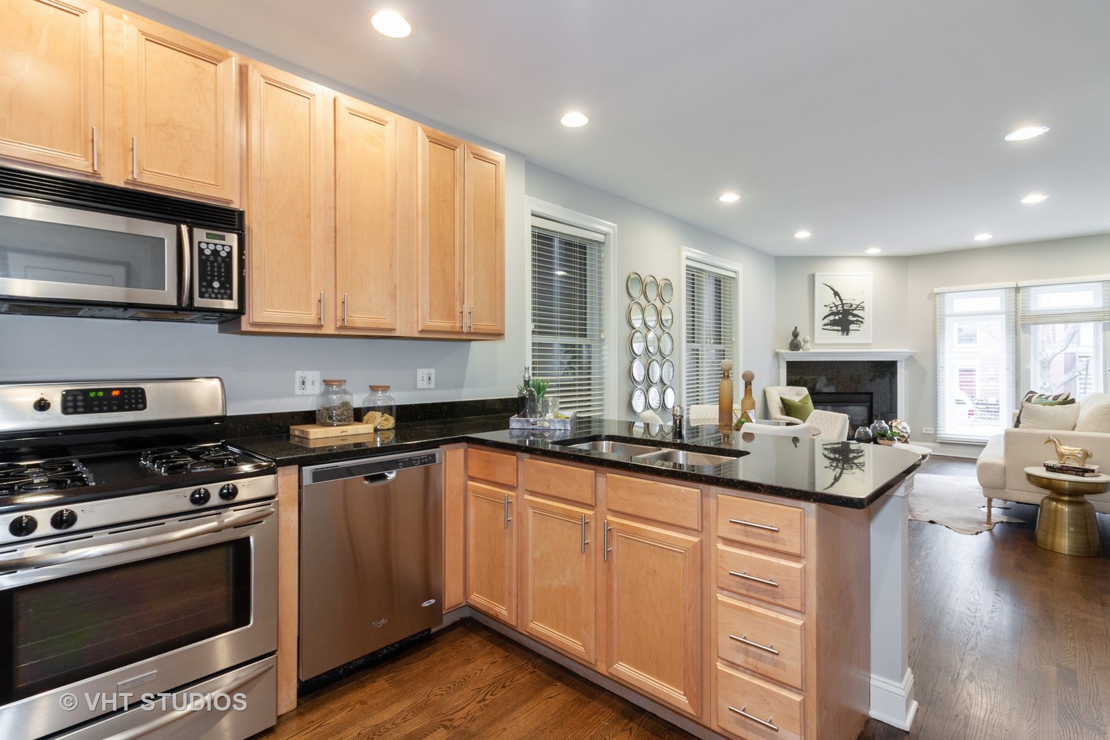 1345 West Fillmore Street, Unit 1 Chicago, IL 60607 - Photo 5 of 26 a kitchen with granite countertop a stove top oven a sink dishwasher and cabinets with wooden floor