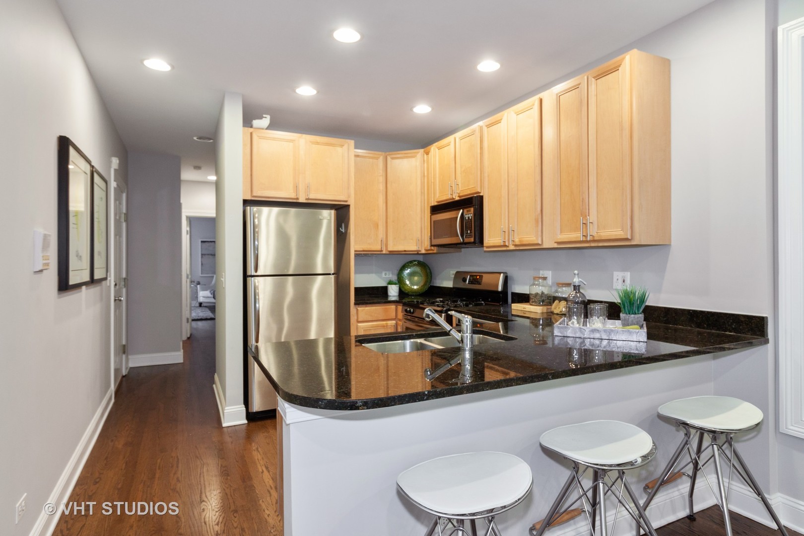 1345 West Fillmore Street, Unit 1 Chicago, IL 60607 - Photo 6 of 26 a kitchen with stainless steel appliances granite countertop a refrigerator a sink dishwasher a stove a microwave oven with white cabinets and wooden floor