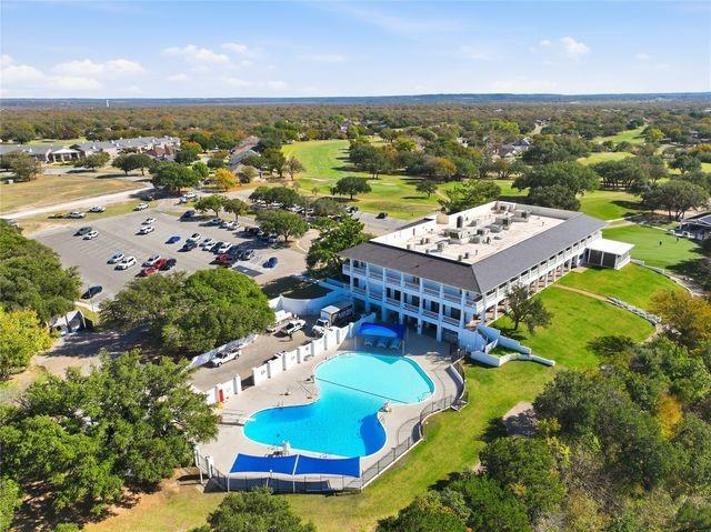 5409 Wedgefield Road Granbury, TX 76049 - Photo 38 of 39 Expansive property featuring a multi-story building, large parking area, and an outdoor swimming pool complex