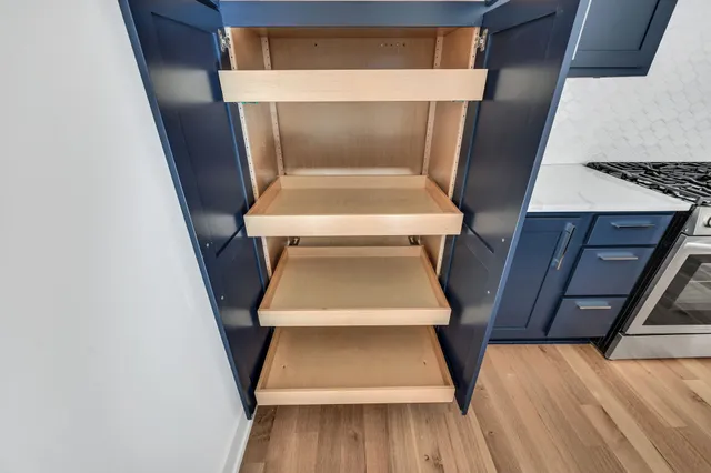 a kitchen with kitchen island a oven a chimney a refrigerator and wooden cabinets