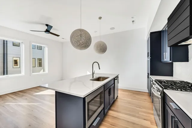a view of empty room with wooden floor and ceiling fan
