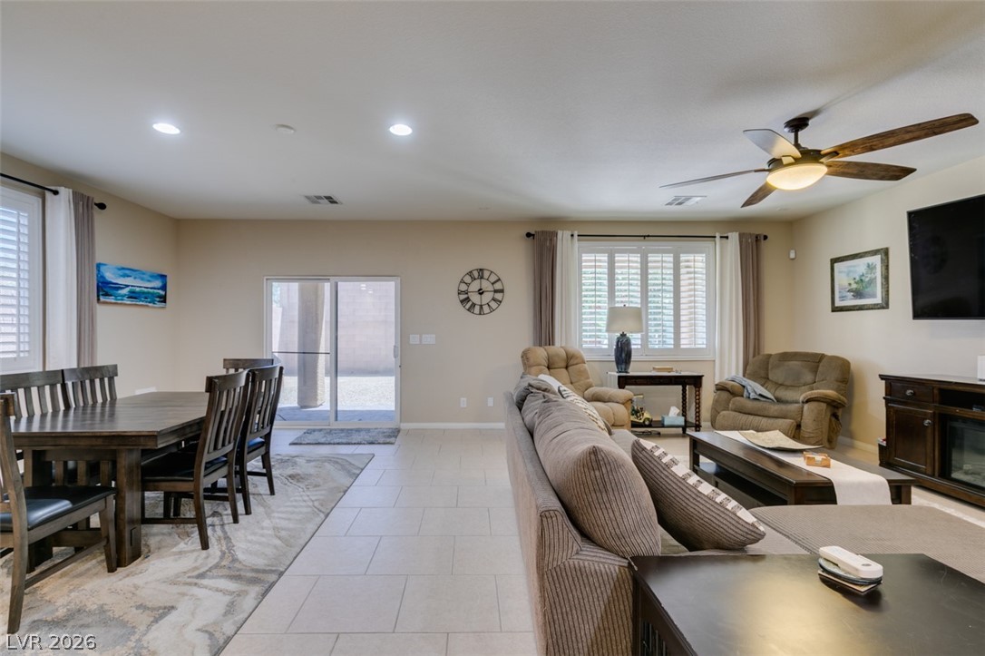 7375 Campbell Ranch Avenue Las Vegas, NV 89179 - Photo 7 of 45 The open-concept living space integrates dining and lounge areas, featuring neutral tones.